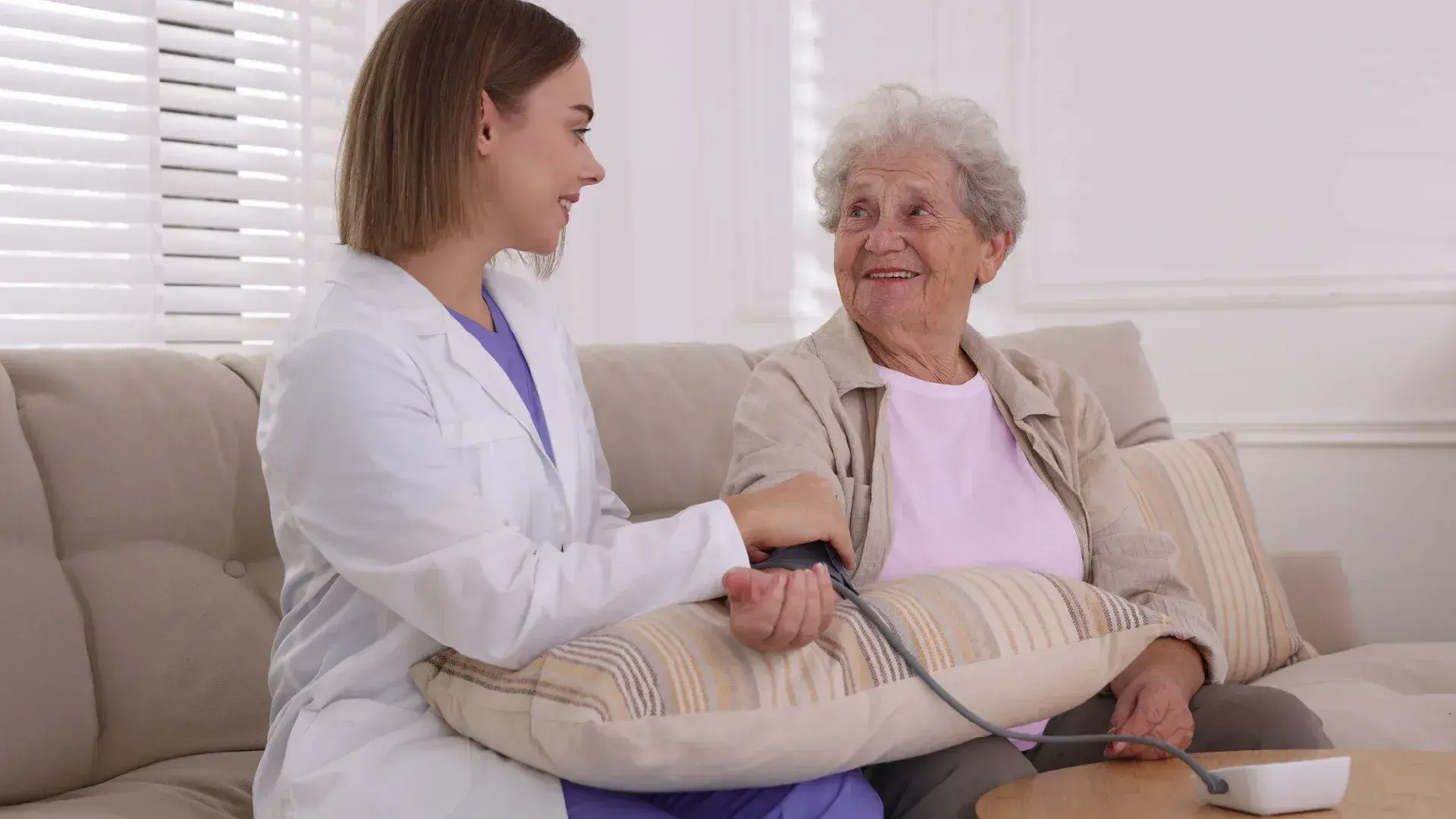 A doctor checking an elderly patient's blood pressure